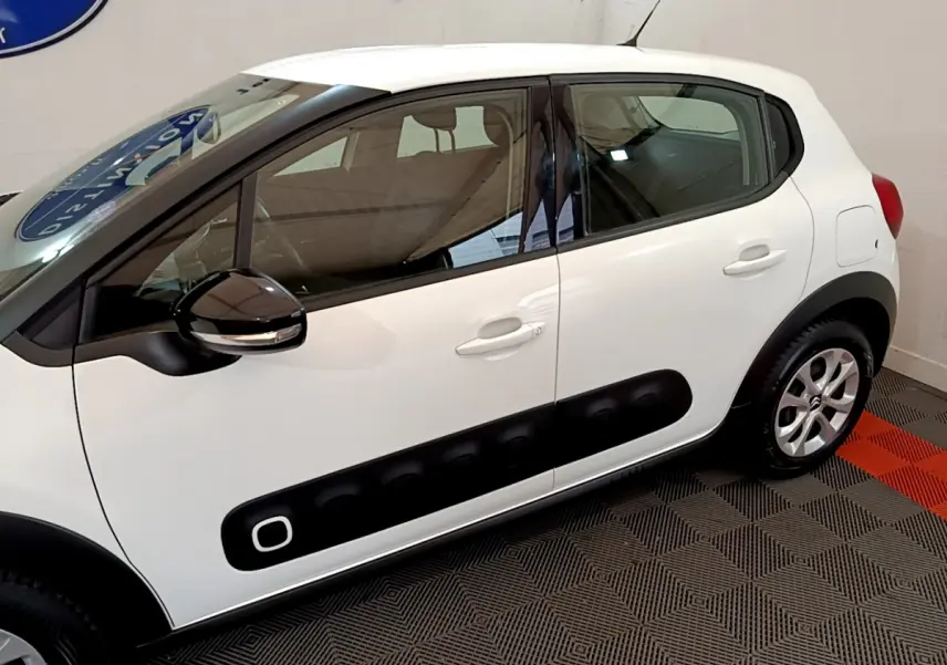 Vue de profil côté gauche d'une Citroën C3 blanche avec protections latérales noires et rétroviseur bicolore.