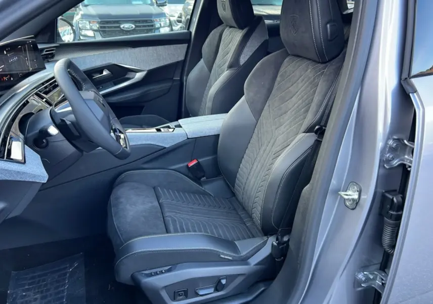 Vue intérieure côté conducteur du Peugeot 3008 Hybrid 145 GT Alcantara 2025, sièges en cuir et alcantara gris, détails couture apparents.