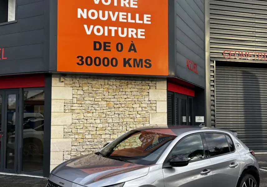 Peugeot 208 Hybrid 110 e-DCS6 GT gris clair vue 3/4 avant droit avec phares LED et jantes noires.