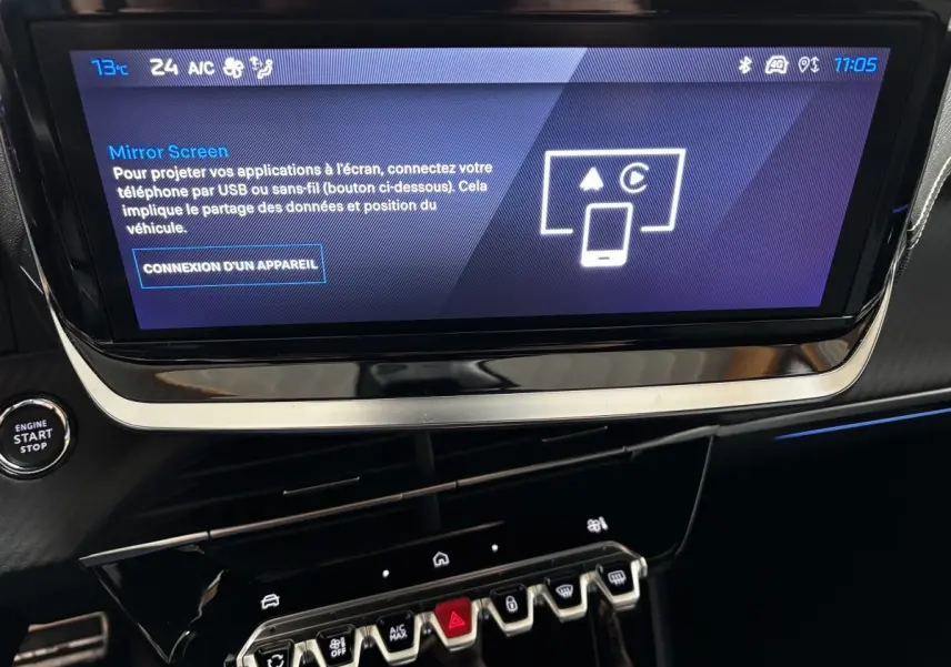 Écran tactile central affichant Mirror Screen, tableau de bord noir avec bouton start/stop dans une Peugeot 208 Hybrid gris clair.
