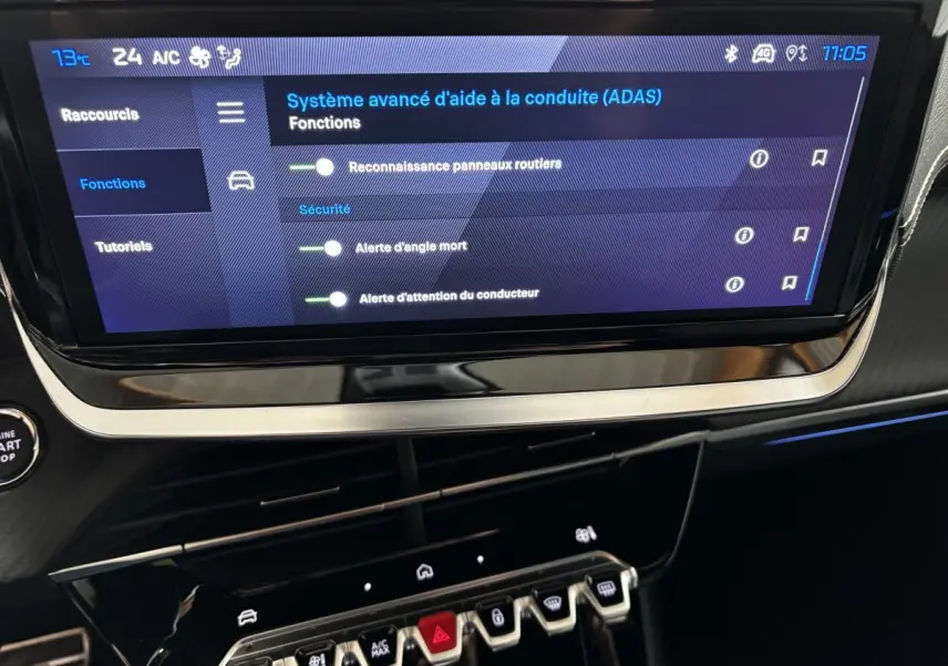 Écran tactile central affichant les aides à la conduite dans l’habitacle noir du Peugeot 208 Hybrid 110 e-DCS6 GT.