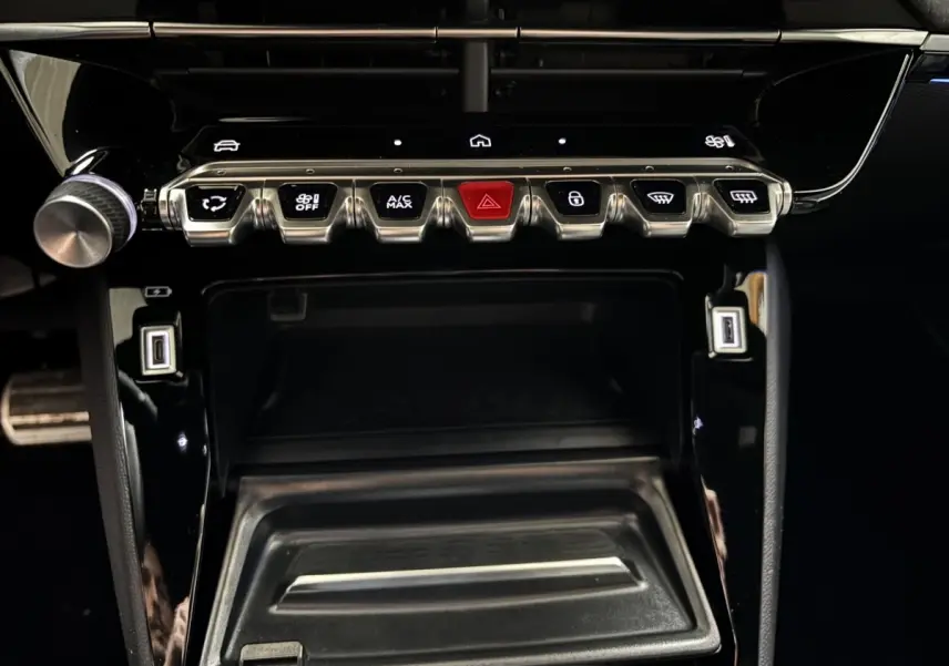 Vue rapprochée de la console centrale noire de la Peugeot 208 Hybrid 110 e-DCS6 GT avec boutons métalliques et écran tactile.