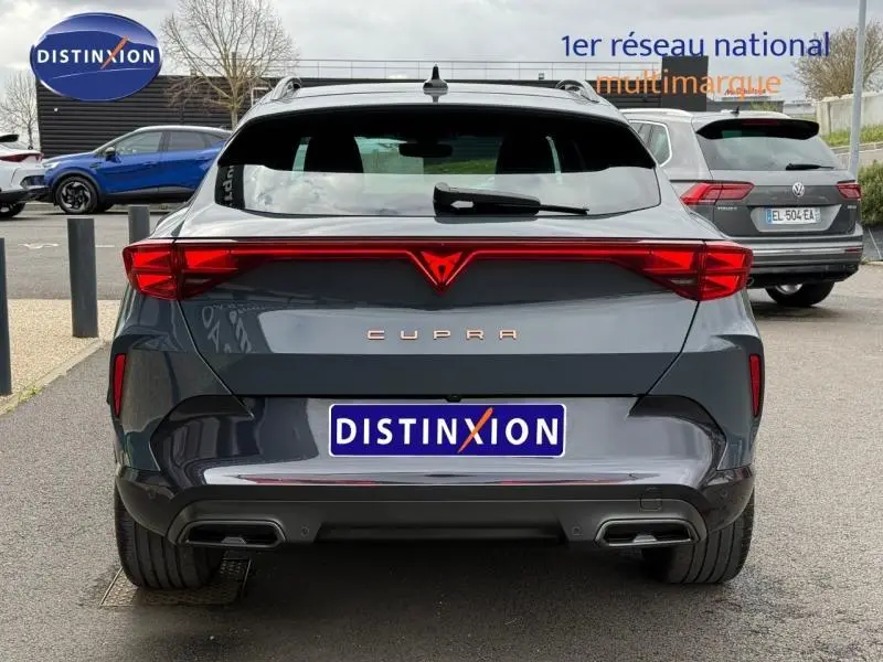 Vue arrière d'une CUPRA Formentor bleu foncé avec feux arrière LED et double sortie d'échappement.