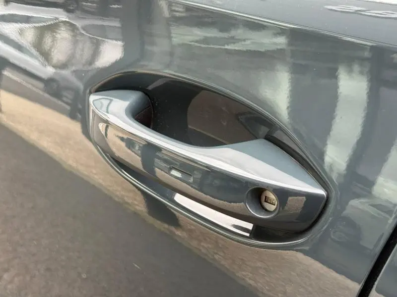 Poignée de porte côté gauche en gros plan sur CUPRA Formentor bleu Fjord 2025 avec serrure visible.