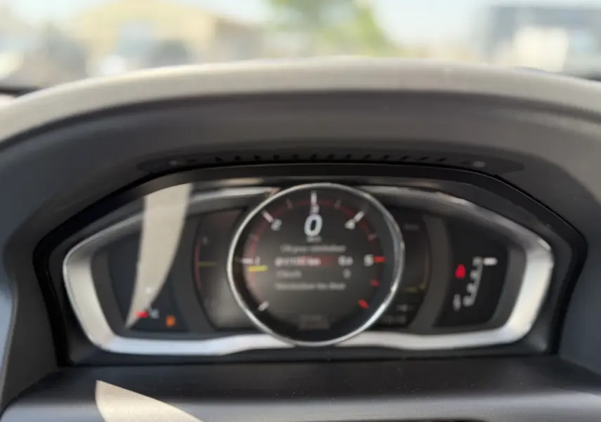 Vue rapprochée du tableau de bord numérique du Volvo XC60 gris foncé, affichant le compteur de vitesse au centre.