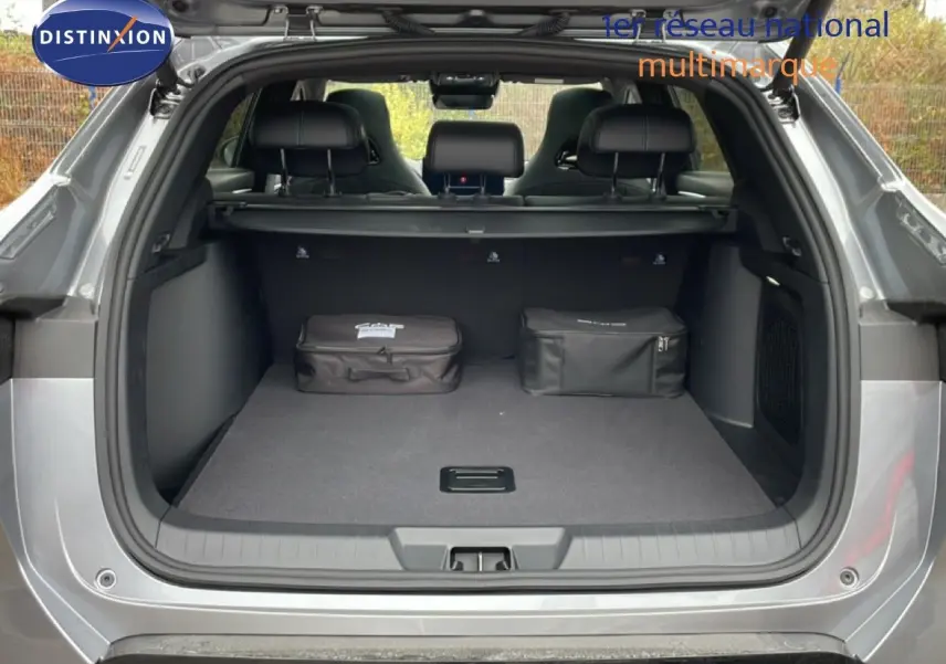 Coffre ouvert vu de l'arrière d'un BYD SEAL U 2026 gris métallisé avec deux sacs noirs posés à l'intérieur.