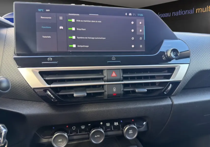 Vue rapprochée du tableau de bord central de la Citroën C4 hybride 2025, écran tactile et commandes climatisation visibles.
