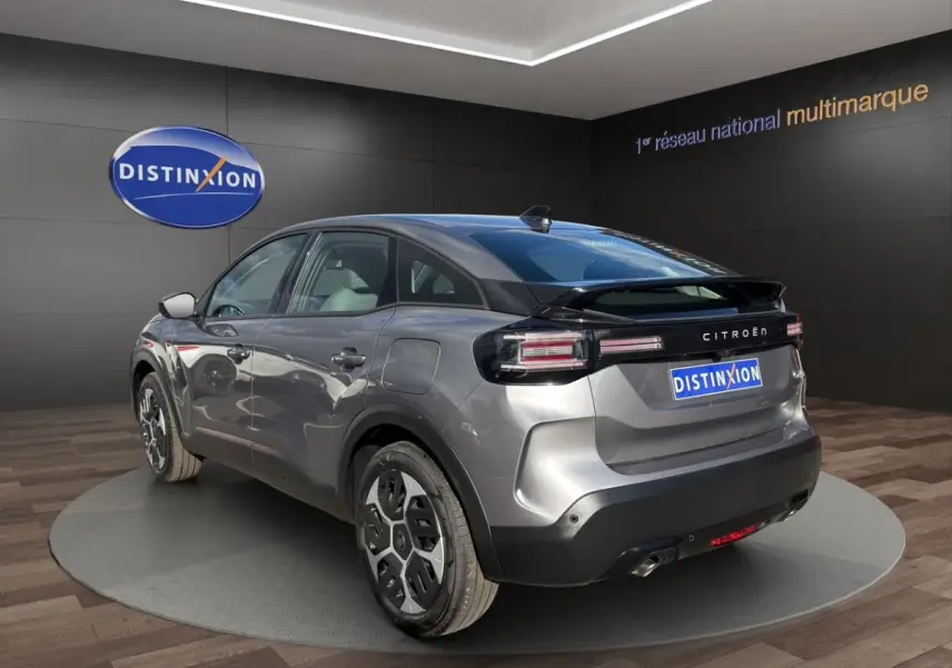 Vue 3/4 arrière droite d'une Citroën C4 hybride gris foncé avec feux arrière LED et toit noir brillant.