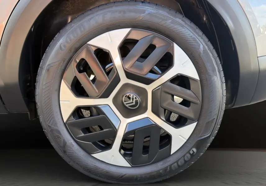 Gros plan sur la roue avant droite gris foncé d'une Citroën C4 hybride 2025 avec jante au design géométrique bicolore.