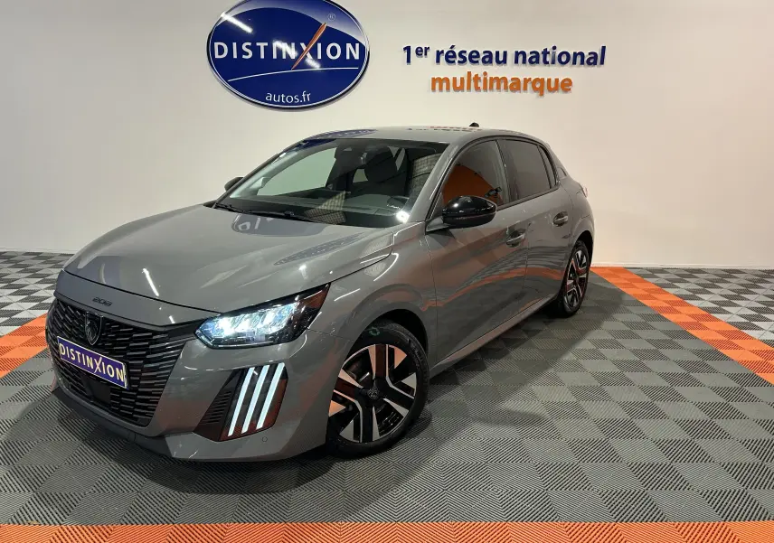 Peugeot 208 gris Selenium vue 3/4 avant droit avec phares LED allumés et jantes noires bicolores.