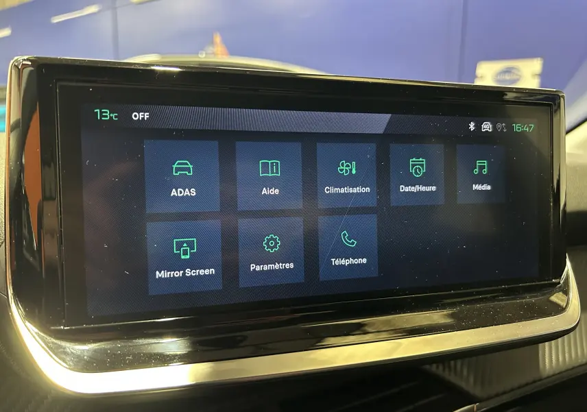 Écran tactile central affichant les options ADAS, climatisation et téléphone dans l’habitacle d’une Peugeot 208 2025.