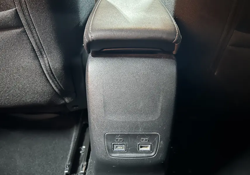Vue rapprochée de la console centrale arrière noire avec deux ports USB sur la Peugeot 208 gris Selenium.