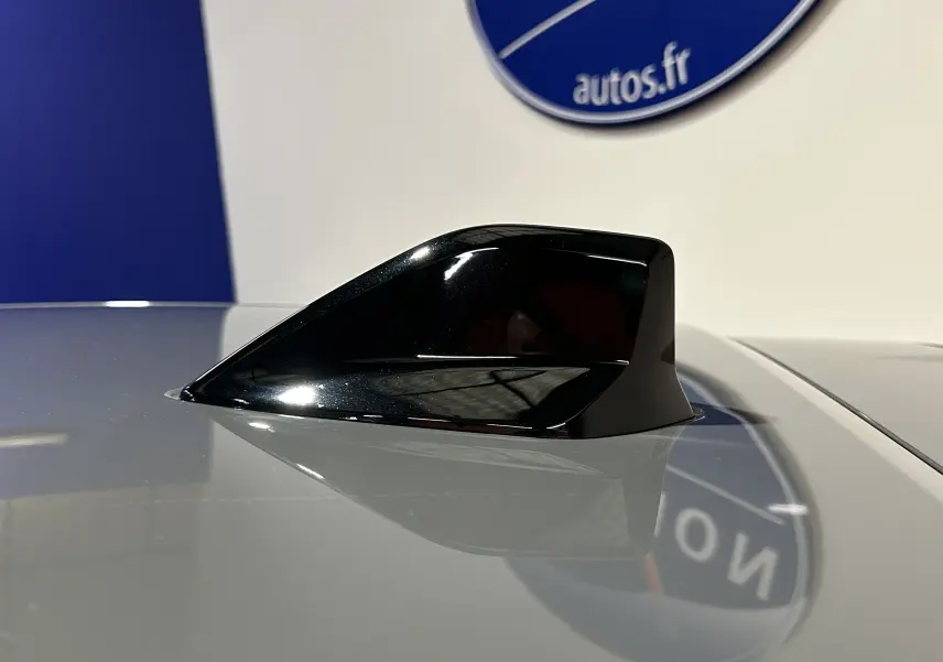 Antenne requin noire en gros plan sur le toit gris Selenium d'une Peugeot 208 II Turbo 100 Allure 2025.