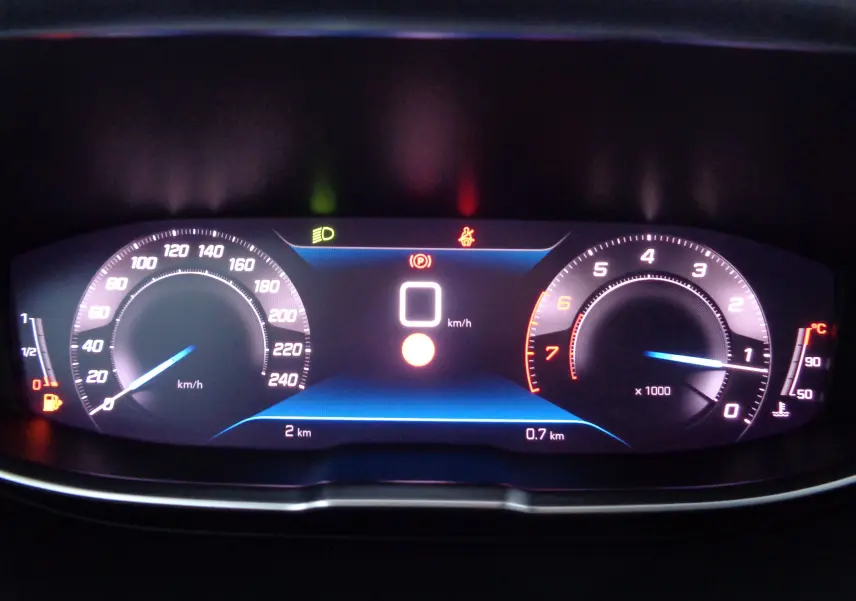 Tableau de bord numérique du Peugeot 5008 2023 affichant vitesse, compte-tours et jauges avec éclairage bleu et blanc.