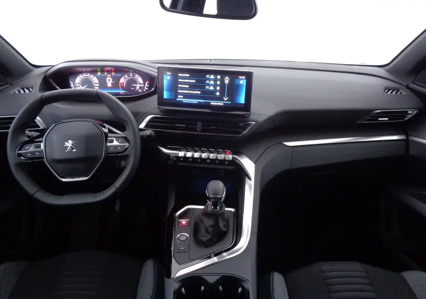 Vue intérieure avant du Peugeot 5008 2023, tableau de bord noir avec écran tactile et volant compact au lion Peugeot.