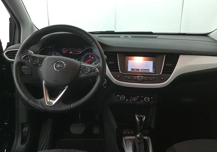 Vue intérieure avant de l'Opel Crossland noir 2022, tableau de bord avec écran central et volant multifonction.