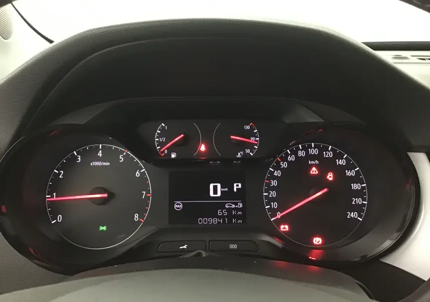 Vue rapprochée du tableau de bord noir de l'Opel Crossland 2022, affichant les compteurs et voyants allumés.