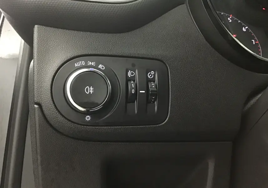 Gros plan sur les commandes d'éclairage noires à gauche du tableau de bord de l'Opel Crossland noir 2022.