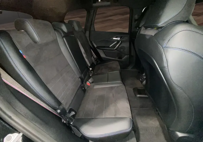 Vue intérieure côté droit des sièges arrière en cuir noir avec surpiqûres bleues du BMW X1 XDRIVE 20D M SPORT 2025.