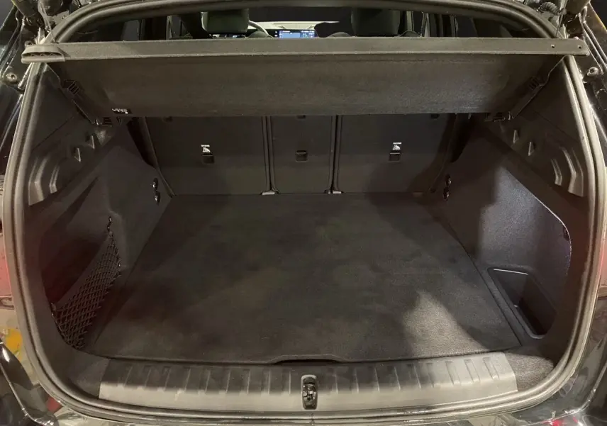Coffre ouvert en vue arrière d'un BMW X1 noir Saphir, montrant un espace de chargement propre et spacieux.