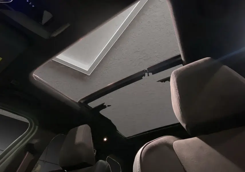 Vue intérieure du toit ouvrant panoramique du BMW X1 XDRIVE 20D M SPORT BVA noir, mettant en valeur les sièges avant en tissu.