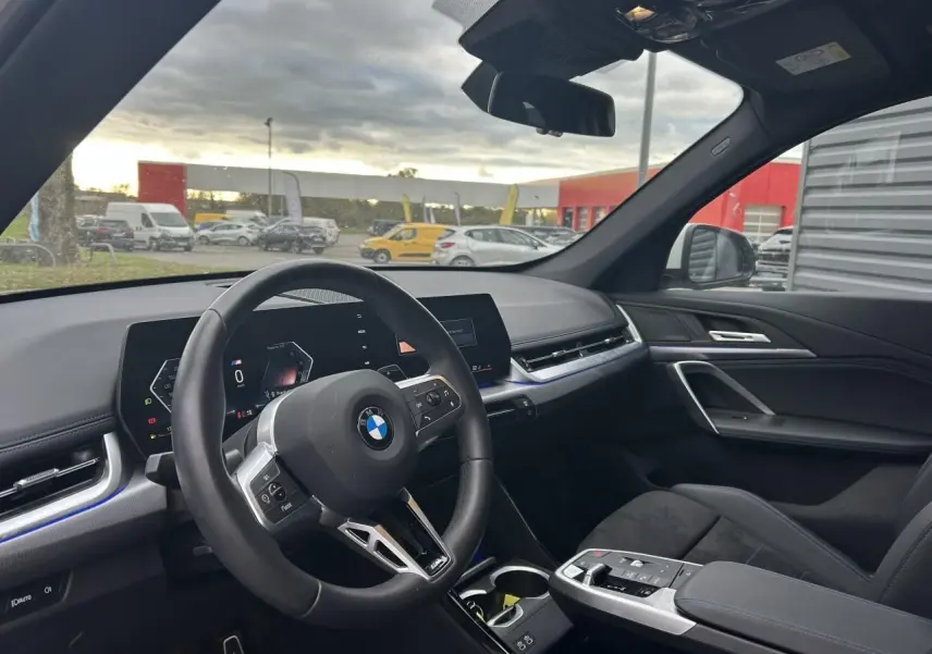 Vue intérieure côté conducteur du BMW X1 2025 Black Saphire, tableau de bord moderne et volant multifonction M Sport.