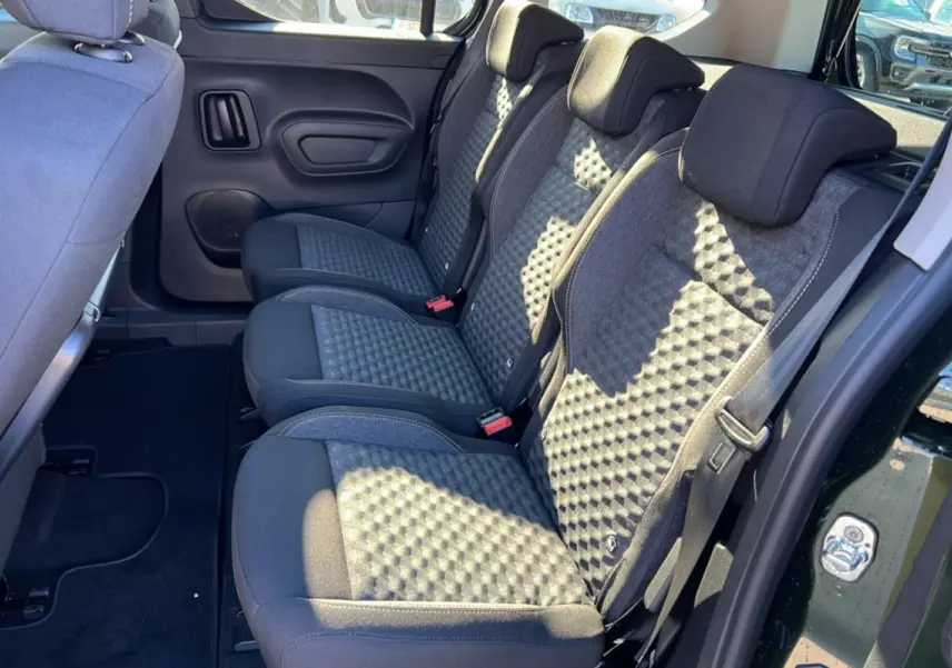 Vue intérieure côté droit des sièges arrière en tissu gris du Peugeot Rifter Vert Sirkka 2025, avec porte ouverte.