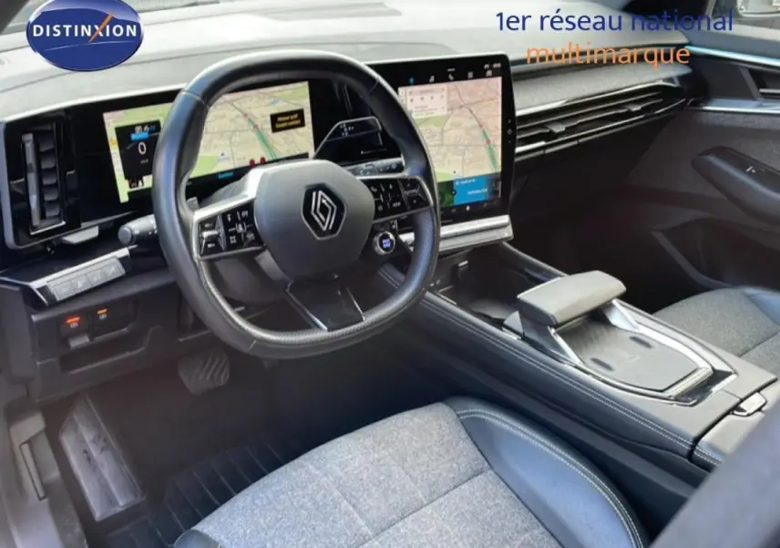 Vue intérieure côté conducteur du Renault Espace 2024 gris, avec volant cuir multifonctions et grand écran tactile GPS.