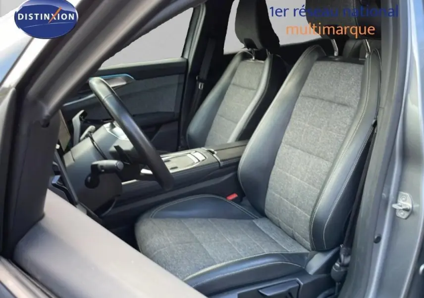 Vue intérieure côté conducteur du Renault Espace gris 2024, sièges tissu et cuir bicolores avec volant multifonctions.