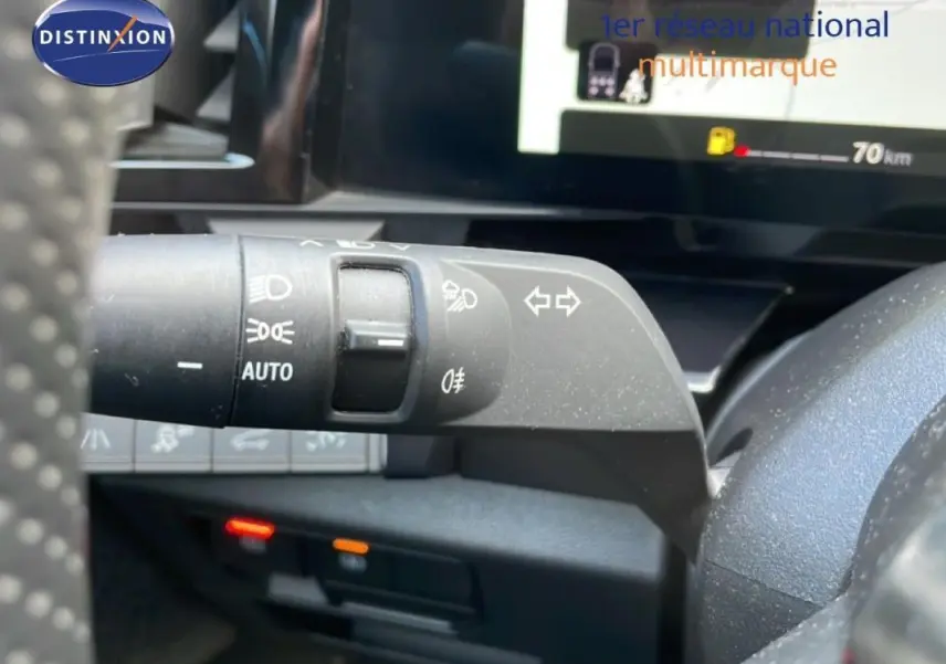 Gros plan sur la commande des feux et clignotants à gauche du volant du Renault Espace gris 2024 hybride.