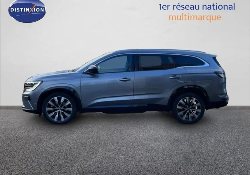 Profil latéral droit d'un Renault Espace gris 2024 avec jantes aluminium et barres de toit visibles.