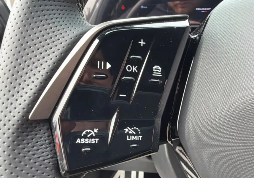 Gros plan sur les commandes du volant cuir perforé du Peugeot 3008 Hybrid 145 GT Alcantara, finition noire brillante.