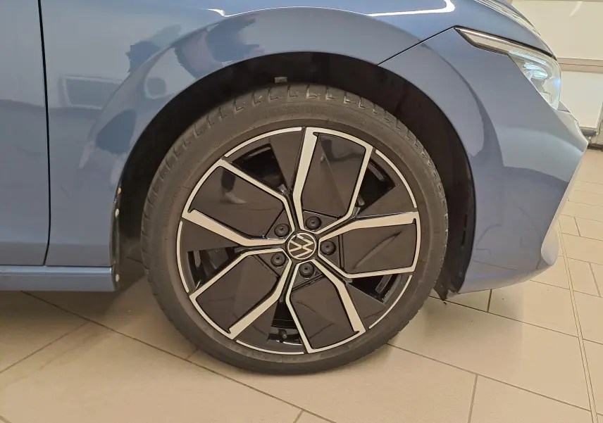 Gros plan sur la roue avant gauche de la Volkswagen Golf 1.5 eTSI 150 DSG7 Bleu Anémone avec jante noire et argentée.