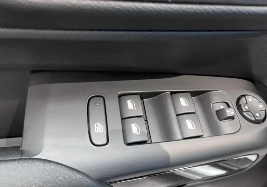 Gros plan sur les commandes de lève-vitres et rétroviseurs côté gauche d’une Citroën C5 Aircross gris platinium.