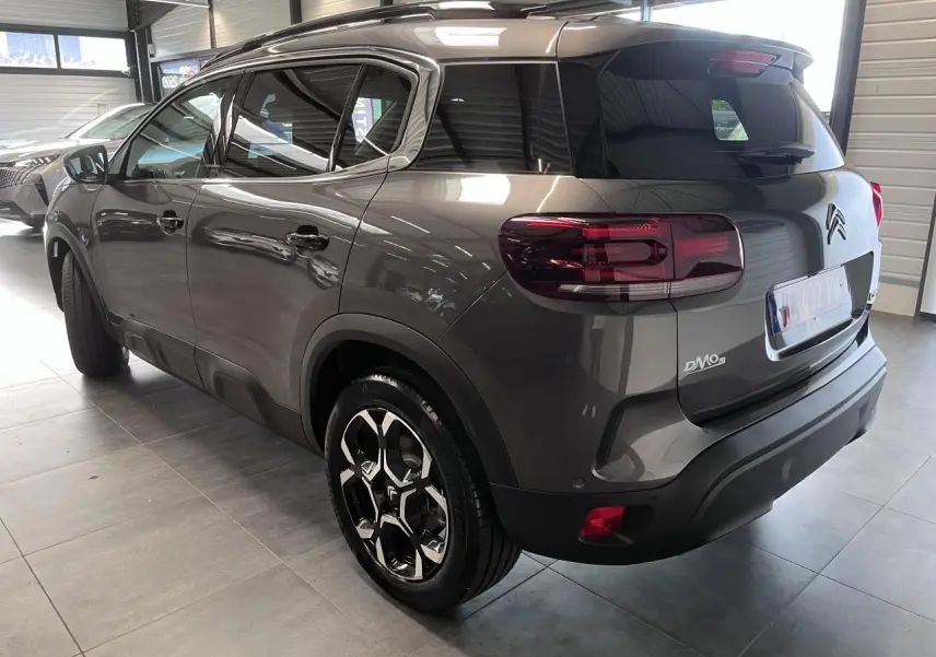Vue 3/4 arrière droit du Citroën C5 Aircross gris platinium avec jantes alliage bi-ton et vitres teintées.