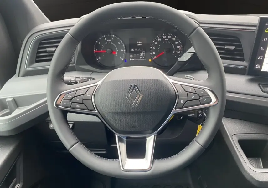 Vue rapprochée du volant noir du Renault Master 2026 avec tableau de bord numérique et commandes intégrées.
