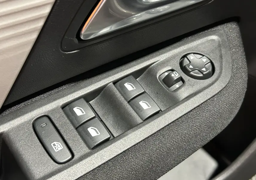 Gros plan sur les commandes de lève-vitres et réglage des rétroviseurs côté conducteur d’un Citroën E-C4 gris foncé.