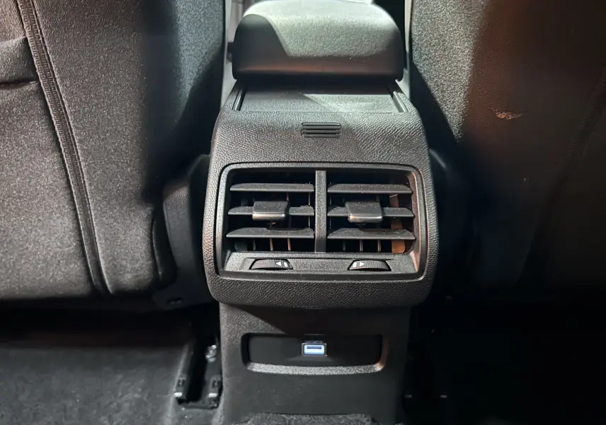 Vue rapprochée des aérateurs arrière et prise USB du Citroën E-C4 gris foncé, intérieur noir.