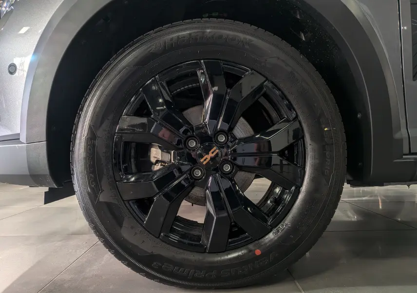 Gros plan sur la roue avant droite noire brillante du Dacia Sandero Stepway Gris Schiste 2025.