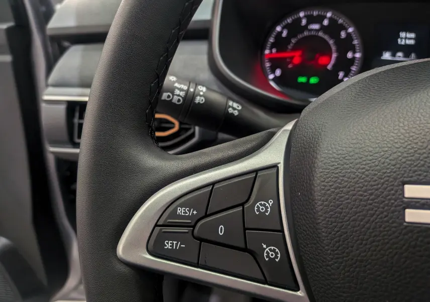 Gros plan sur le volant noir du Dacia Sandero Stepway 2025, avec commandes de régulateur de vitesse visibles à gauche.