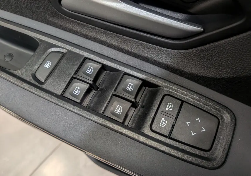 Panneau de commandes des vitres et réglages des rétroviseurs côté conducteur dans une Dacia Sandero Stepway 2025 gris schiste.