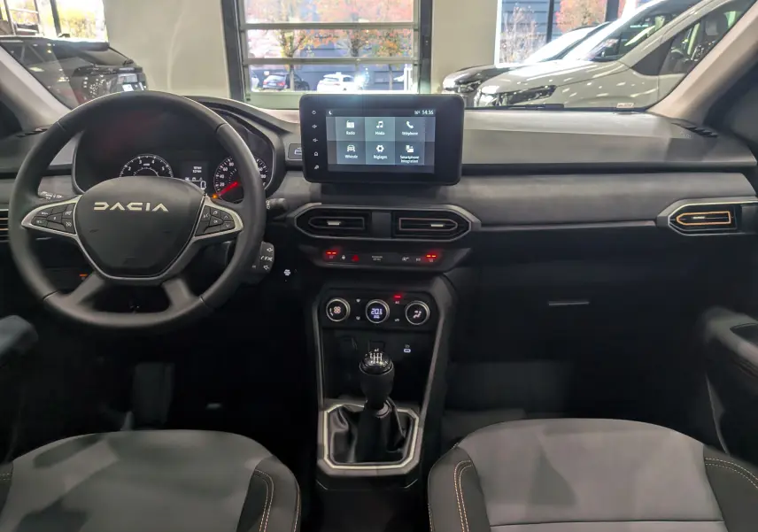 Tableau de bord intérieur de la Dacia Sandero Stepway TCe 110 gris schiste, vue frontale centrée sur le volant et l'écran tactile.