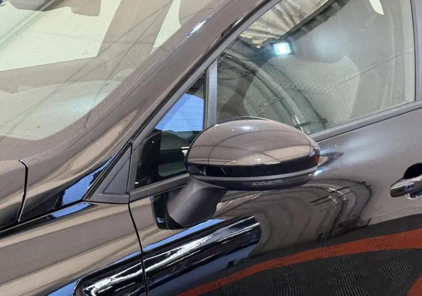 Rétroviseur côté gauche noir brillant de la Renault Clio Evolution Blue dCi 100 -25 avec porte et vitre arrière visibles.