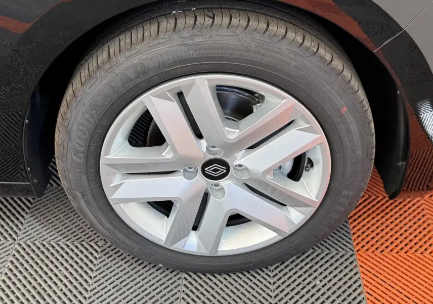 Gros plan sur la roue avant droite d'une Renault Clio noire 2025 avec jante alliage et logo central Renault.