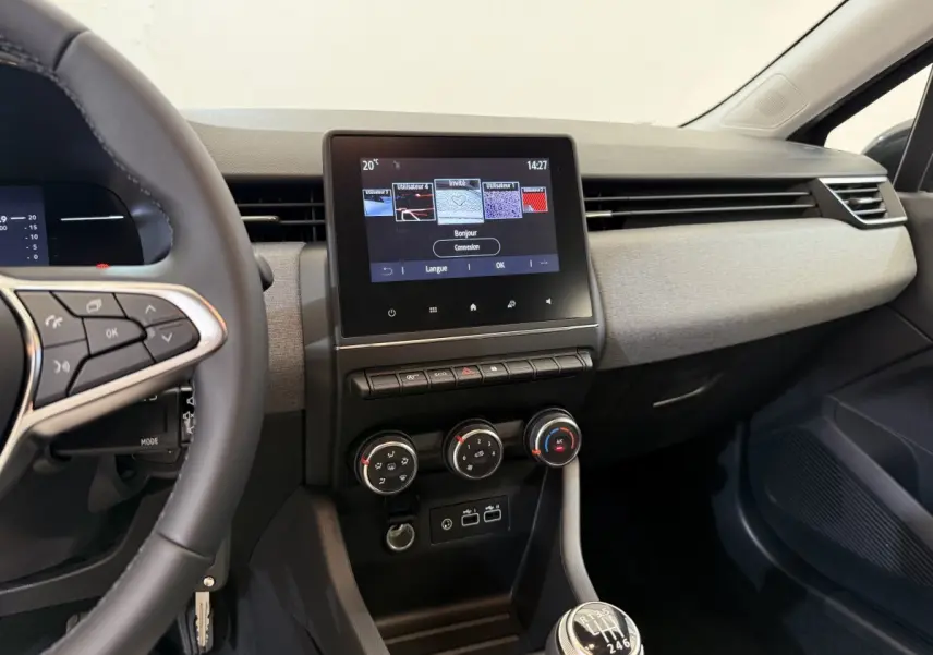 Vue intérieure du tableau de bord et console centrale de la Renault Clio noire 2025 avec écran tactile et boîte manuelle.