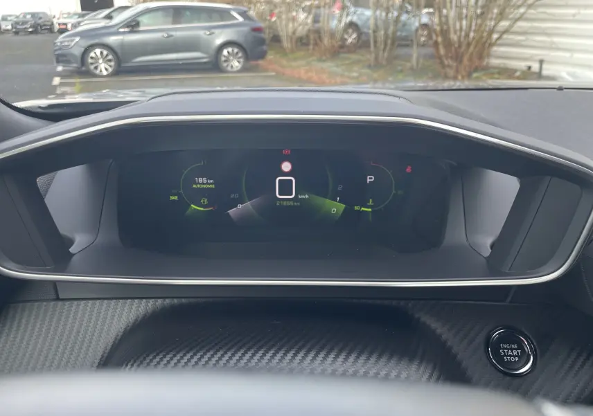 Tableau de bord numérique du Peugeot 2008 gris Artense, affichage de vitesse et autonomie, bouton start/stop visible.
