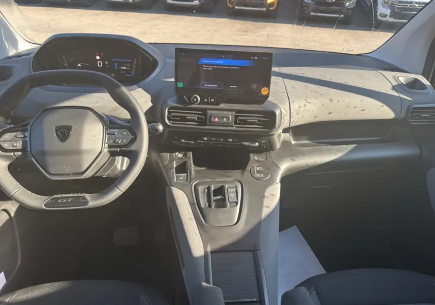 Vue intérieure avant du Peugeot Rifter GT Plus 2025 noir perla nera, avec tableau de bord digital et écran tactile central.