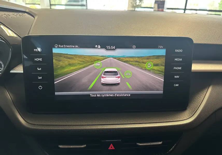 Écran central de la Skoda Fabia 2023 affichant les systèmes d'assistance avec vue arrière virtuelle du véhicule gris argent.
