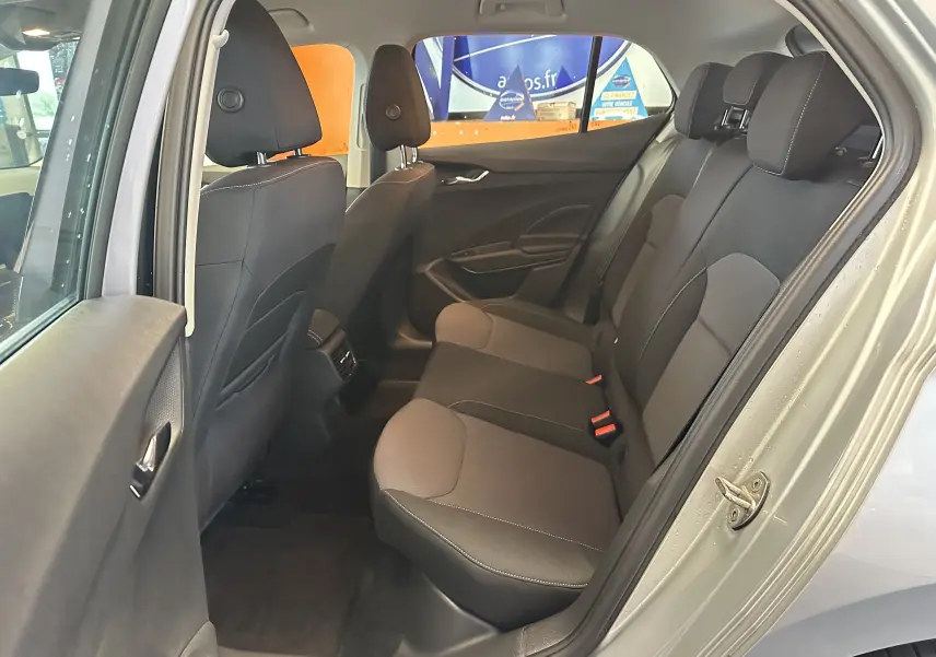 Vue intérieure arrière côté droit de la Skoda Fabia Ambition 2023, sièges tissu gris et noir avec appuie-têtes intégrés.