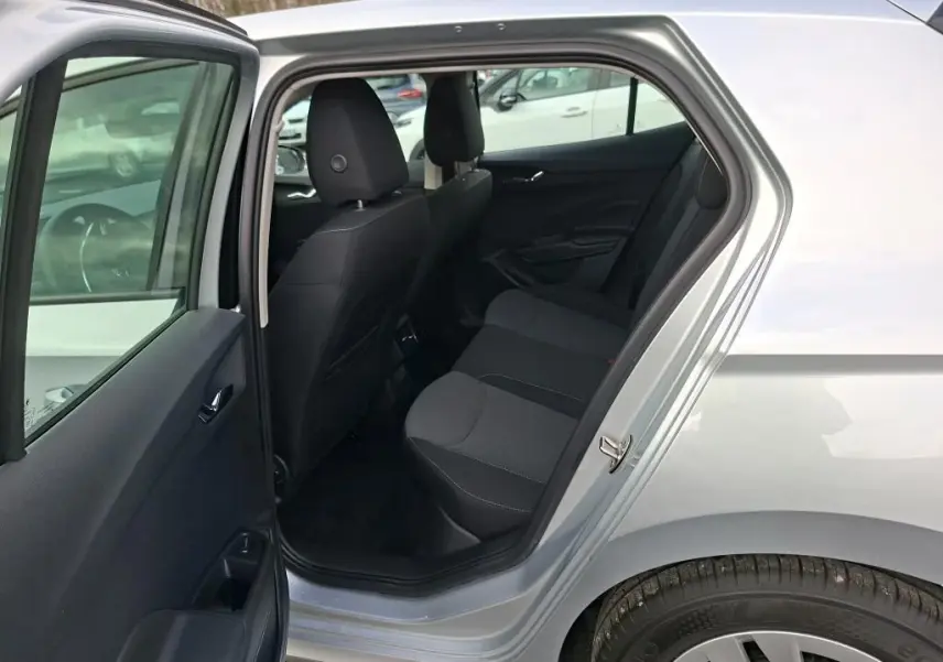 Vue côté gauche arrière de l’habitacle ouvert d’une Skoda Fabia Ambition gris argent 2023, sièges noirs visibles.